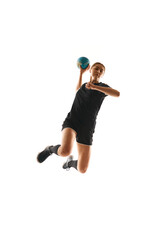 Action shot of young woman, professional handball player passionately playing handball, executing...