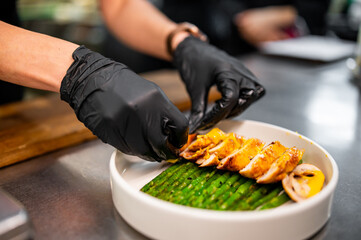 Professional chef cooking Baked fresh asparagus with wrapped meat in restaurant kitchen