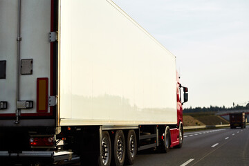 Delivery and shipping of goods by semitrailer trucks. The trucks drive on the road with containers of cargo. They are involved in the export and import of products for the global market.