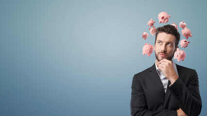 Pensive businessman with piggy banks around his head