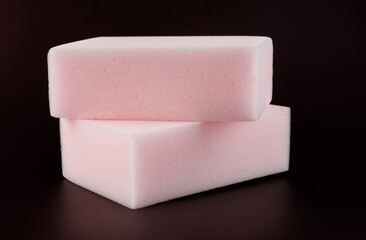 Melamine sponge on a dark red background.