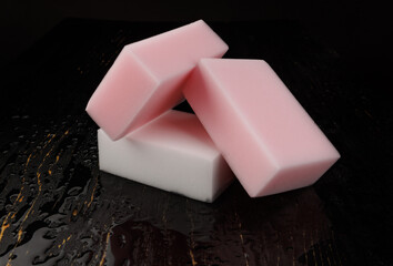Melamine sponge on a black wet background. Beautiful drops of water around a melamine sponge.