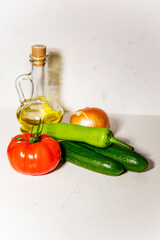 Tomato, pepper, olive oil and cucumber vegetables for salad on white background. Still life of food with copy space for text. Healthy lifestyle concept vertical
