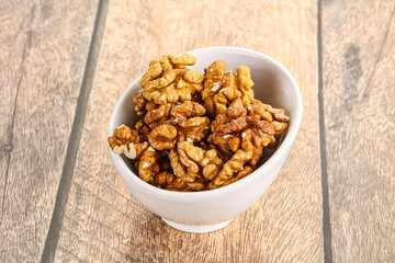 Cracked unshelled walnut in the bowl