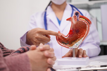 An Asian female doctor examined gastritis and found cancer in the patient's stomach. The female patient appeared stressed. A female doctor explains how to treat and comfort her patient.