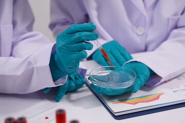 Hands of a doctor or female doctor collecting blood sample tubes from rack with analyzer in lab....