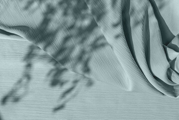 Abstract floral sun light shadows on pastel green blue crumpled textured cloth background, elegant neutral spring sustainable backdrop for business branding