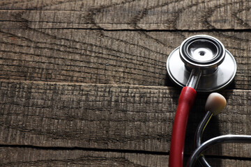 Red stethoscope on a wooden desk. healthcare.