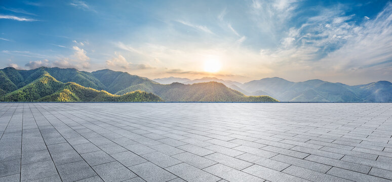 Empty square floor and green mountain with sky clouds at sunset. Panoramic view.