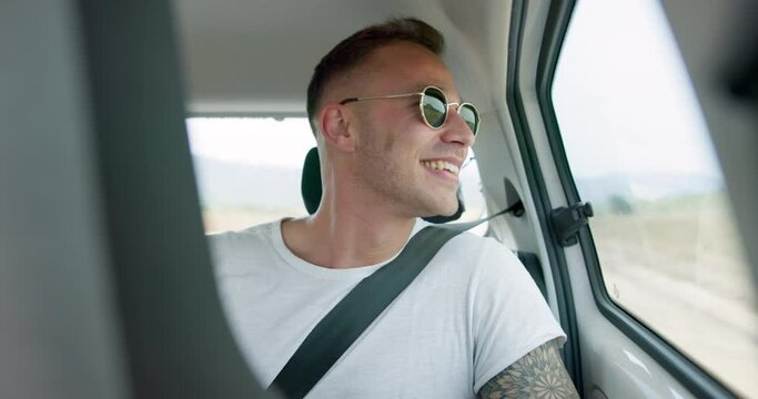 Happy man, car and sunglasses on road trip in backseat for travel, journey or adventure in the countryside. Male person smile in joy looking out vehicle window for natural scenery, holiday or weekend