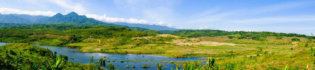 Fototapeta na wymiar a small lake surrounded by small dry rice fields 