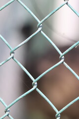 Fototapeta premium Close-up shot of a chain-link fence against a blurry background