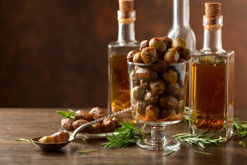 Spicy olives and bottles of olive oil on a wooden table.