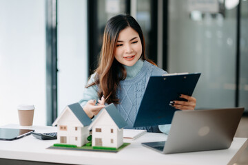 Young real estate agent worker working with laptop and tablet at table in office.