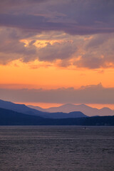 Panoramic sunrise or sunset landscape nature coastal scenery with beautiful fire sky and dramatic cloudscapes in Alaska Inside Passage glacier mountain range view