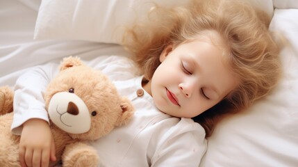 A little girl with blonde hair sleeps on a bed with a soft toy bear in her arms. A child's sweet sleep