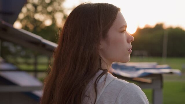 Depressed woman stands against sunset. Young woman tries coping with depressive state by spending time in fresh air close to evening. Hopelessness feelings