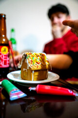 gingerbread house and christmas cookies at table close up