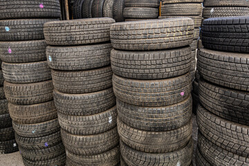vertical stacks of used good condition tires for cars, close full-frame background