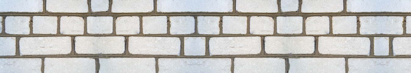 An image of the texture of a brick wall with a coarse-grained, embossed surface. Small cracks and cement inclusions. Horizontal image. Banner for insertion into site. Template for interior design.