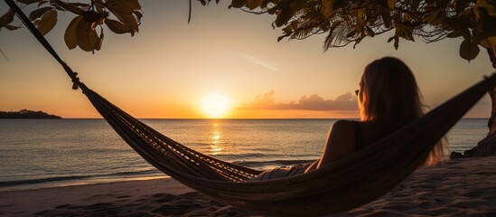 woman in hammock enjoying beach and sunset on tropical beach