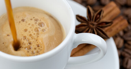 Pouring coffee in white cup. Coffee with cinnamon