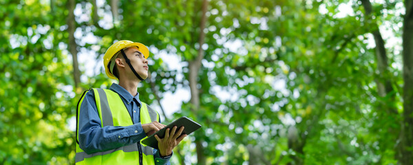 Male engineer wearing a helmet on his head Check the weather conditions of nature and environment....