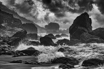 Black and white of the waves of Muir Beach in California crashing against the rocky shoreline