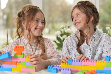 Beautiful girls with colorful blocks at home