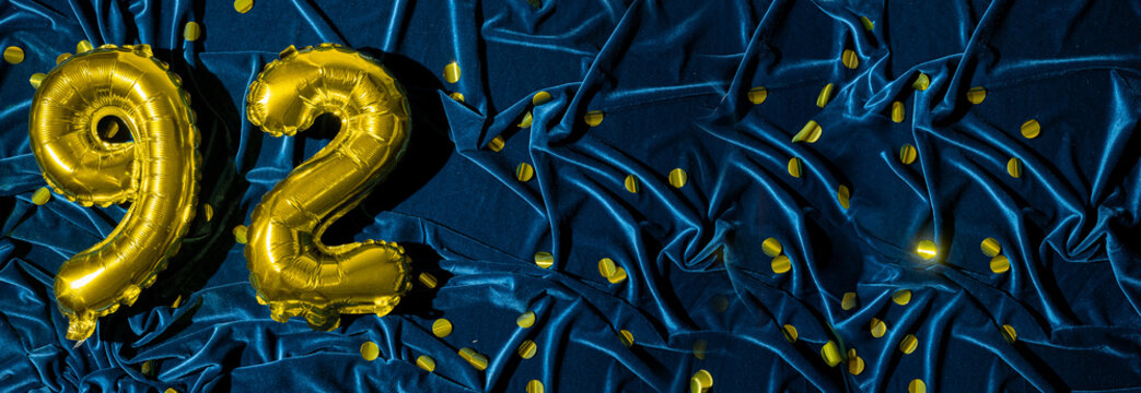 gold foil balloon number ninety two. Birthday or anniversary card with the inscription 92. blue velvet background. Anniversary celebration. Banner.