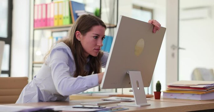 Angry businesswoman trying to break computer screen