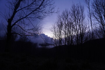 tramonto nuvoloso con cielo colorato e magico di inverno, alberi secchi, Torriglia, liguria