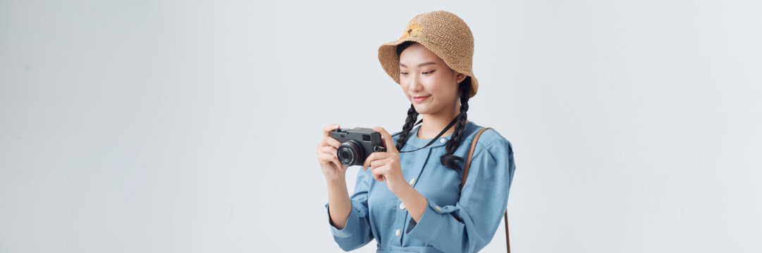 Young girl taking a picture with a small camera on a white background