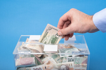Donating or saving cash money in nominal 50 Dollars USD banknotes, The transparent  charity box...