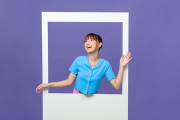 Cute young lady toothy smile hold white photo frame dressed trendy blue clothes