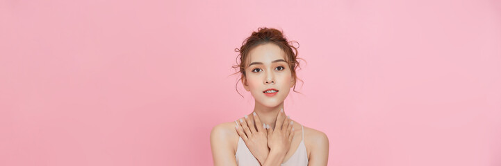 Portrait photo of asian female show her beauty skin care on pink background.