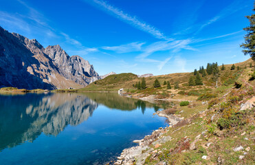 View over beautiful Truebsee mountain lake in Swiss alps near Mount Titlis, Engelberg, Switzerland on sunny day in autumn
