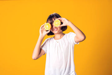 Girl holds half of oranges in hands. Healthy food and children nutrition concept