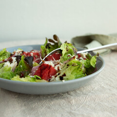 plate with salad with watermelon and feta cheese with balsamic vinegar on the table
