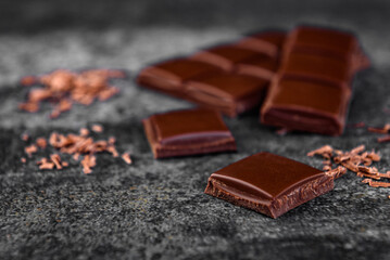 Pieces of milk chocolate on black background.