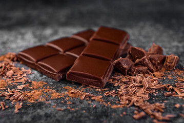 Pieces of milk chocolate on black background.