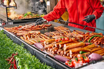 Sausages on the grill at food stall on the street - obrazy, fototapety, plakaty