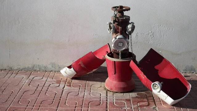 Red broken fire hydrant on the street, close-up
