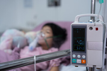 A little Asian girl has an oxygen mask and breathing through a nebulizer at the hospital. Concept...