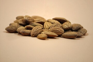 vintage picture of pile of almonds against yellow background, selective focus