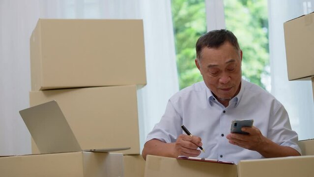 Asian elderly older using laptop and smartphone for checking email order at home office SMEs , Startup small business entrepreneur working online marketing after retirement, merchant seller concept