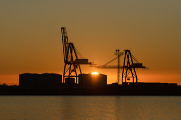 Fototapeta na wymiar port cranes against sunset background