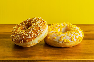 glazed donuts with caramel and apple filling on wooden surface close up