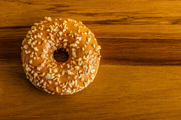caramel glazed donut on wooden surface close up top view