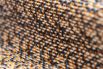 draped, multi-color woven cloth with orange, brown, cream and blue, close up detail macro shot with...